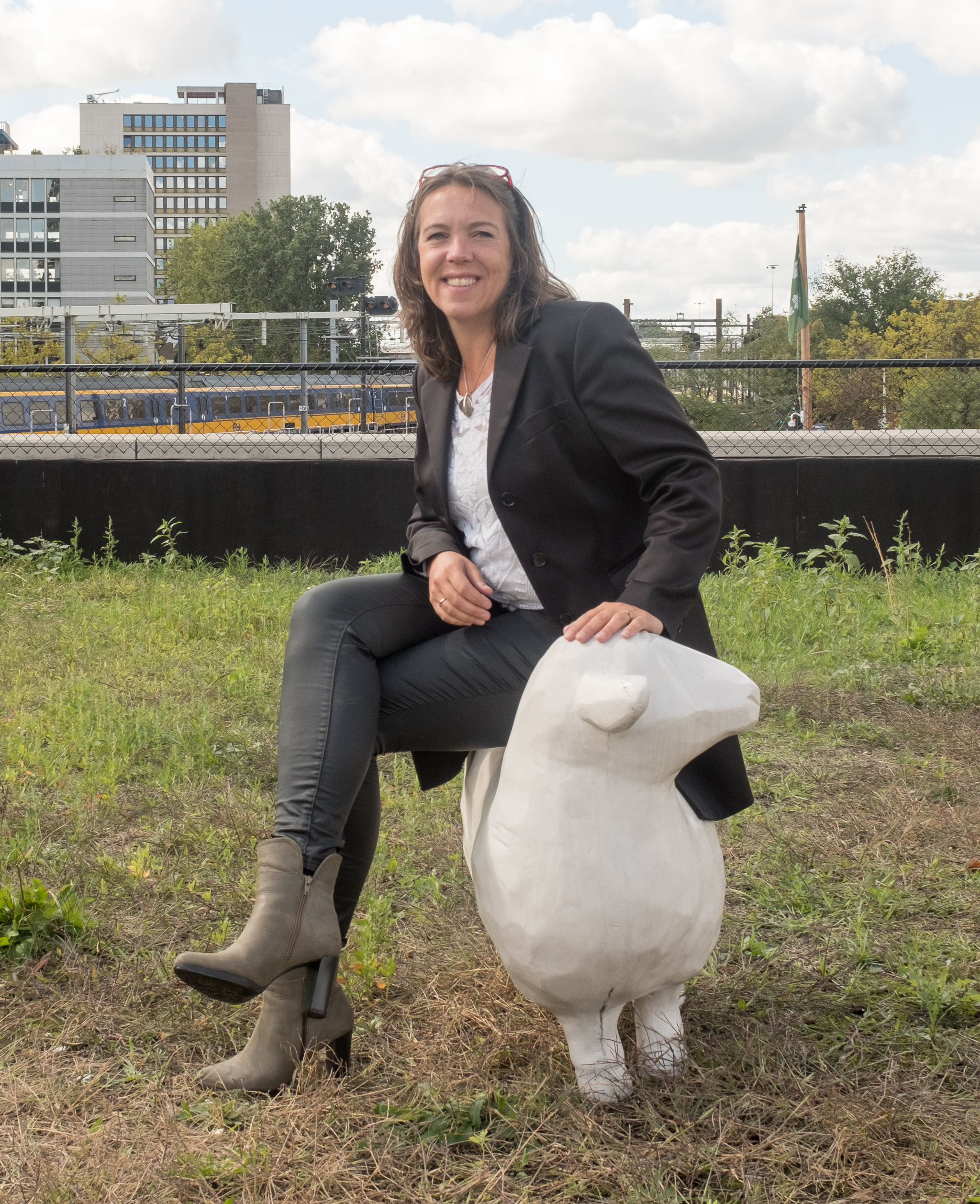 Mickey Starink in Rotterdam centrum zittend op een beeld van een schaap